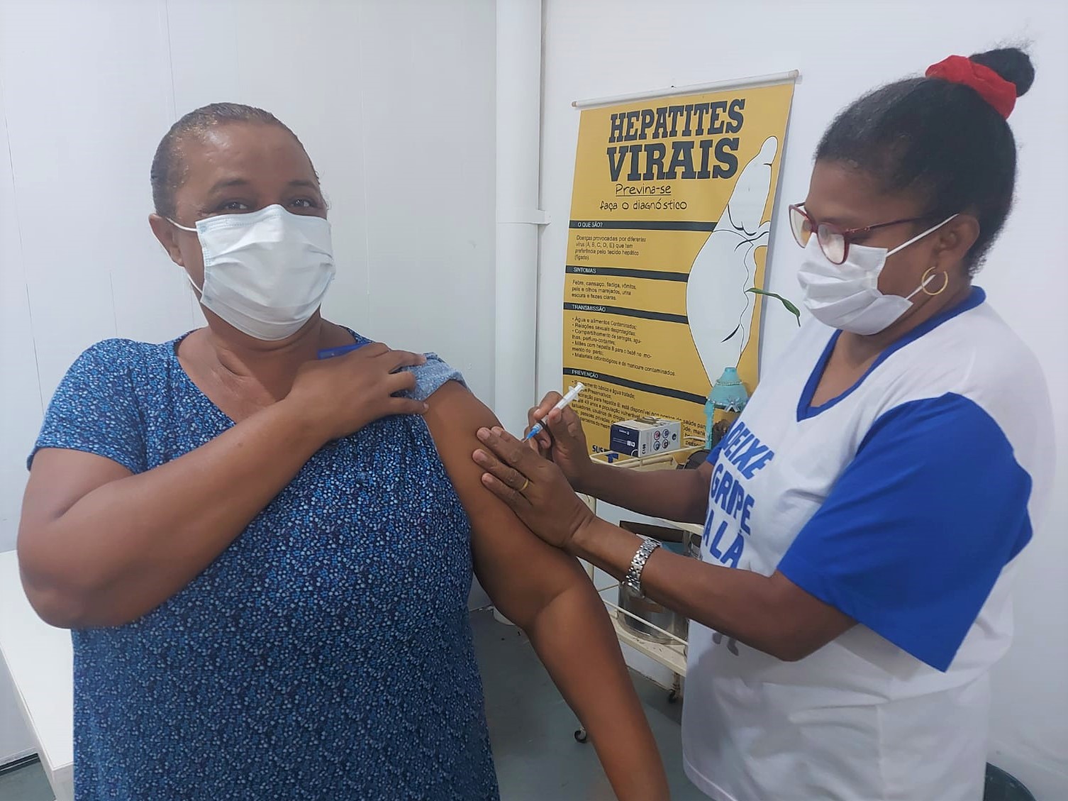 Servidora aposentada recebendo a vacina contra a gripe